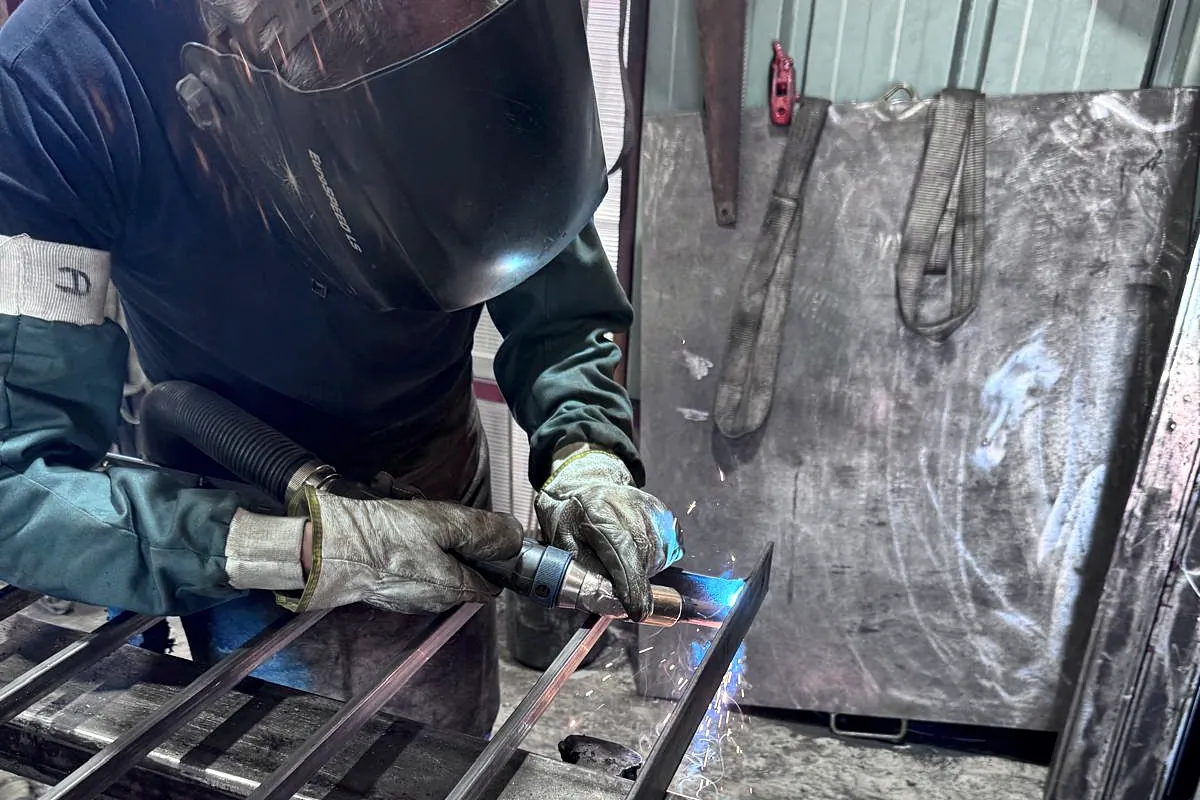Soudeur DERICE soudant une série de barreaux en atelier